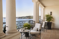 Private terrace with seating area and panoramic lake and city views from The Woodward Geneva suite.