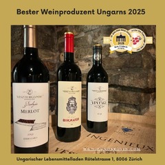 Drei Vesztergombi Weinflaschen: Bodzás Merlot, St. László Bikavér und Vintage stehen auf einem Fass im Keller.